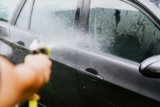 Ponçage humide d'une carrosserie à la cale Feuille de papier abrasif noir et cale souple sur une carrosserie mouillée