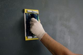 Feuille de papier abrasif noir et cale souple sur une carrosserie mouillée